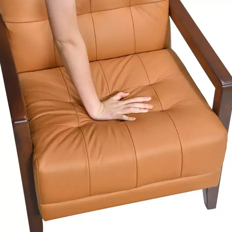 Comoda poltrona d'accento in pelle, contemporanea per il soggiorno, con cuscino imbottito trapuntato e braccioli in legno color noce